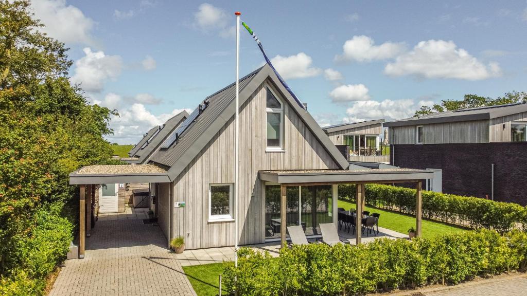 a house with a flag on top of it at Casa Bos Schotsman Wellness in Kamperland