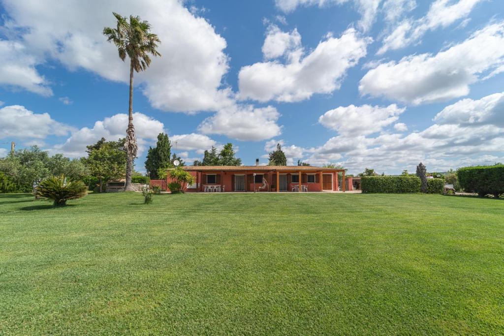SurighedduCasolare di Campagna的棕榈树和大院子的房子