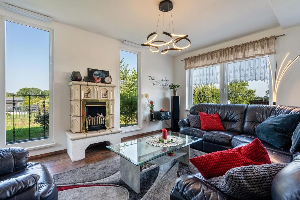 a living room with leather furniture and a fireplace at Ferienhaus Sonja in Lichtenwalde