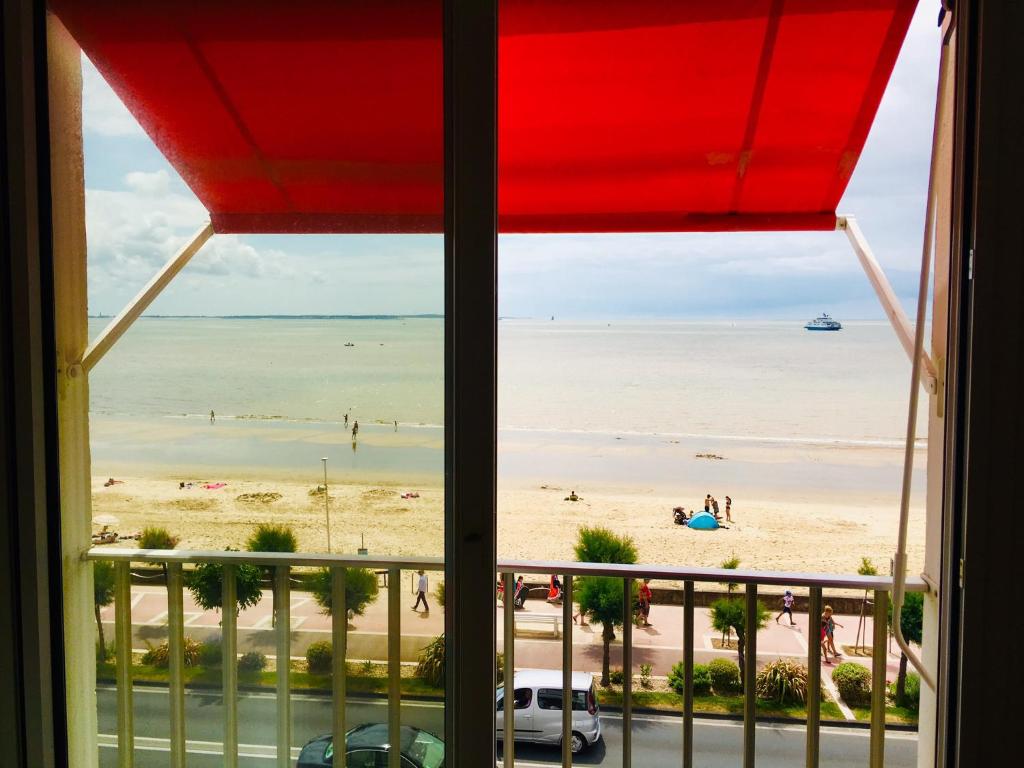 a view of the beach from a window at Merveilleux Studio Face La Mer in Royan