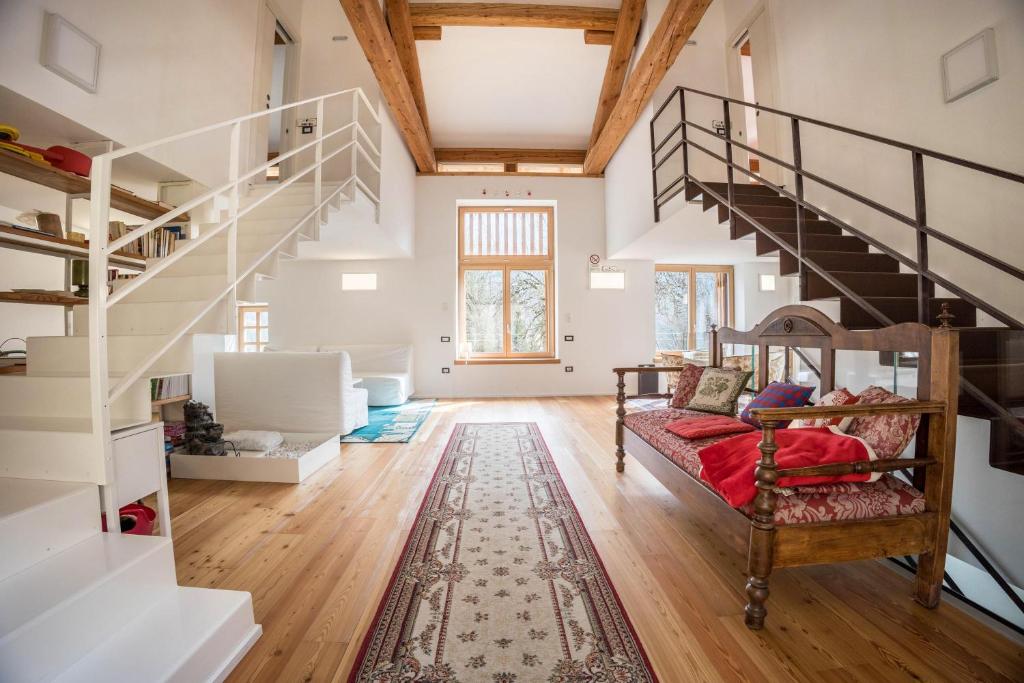 a living room with a staircase and a bed at Villa Iagra in Tiarno di Sopra
