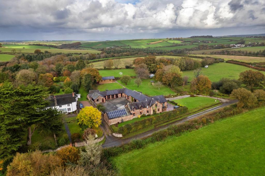eine Luftaufnahme eines großen Hauses auf einem Feld in der Unterkunft Finest Retreats - Halcyon Cottage, Stowford in Little Torrington