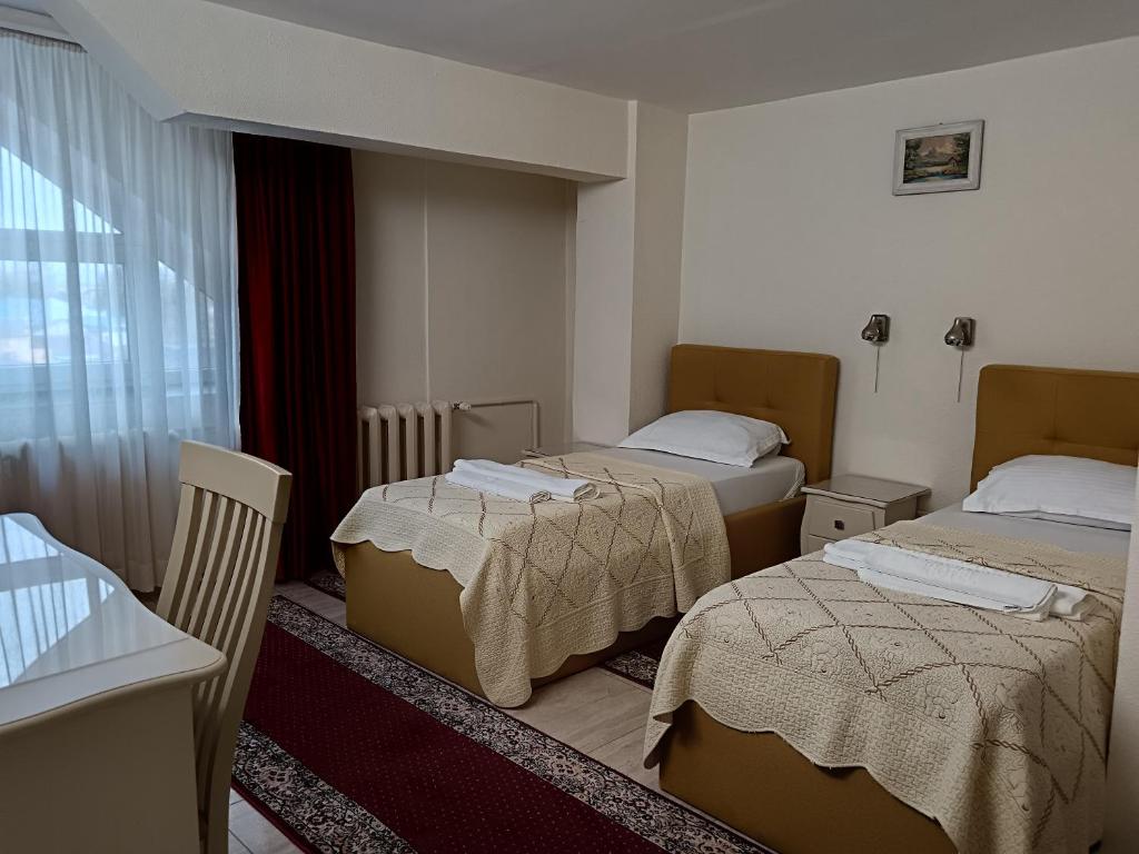 a hotel room with two beds and a window at Hotel Florentina in Constanţa