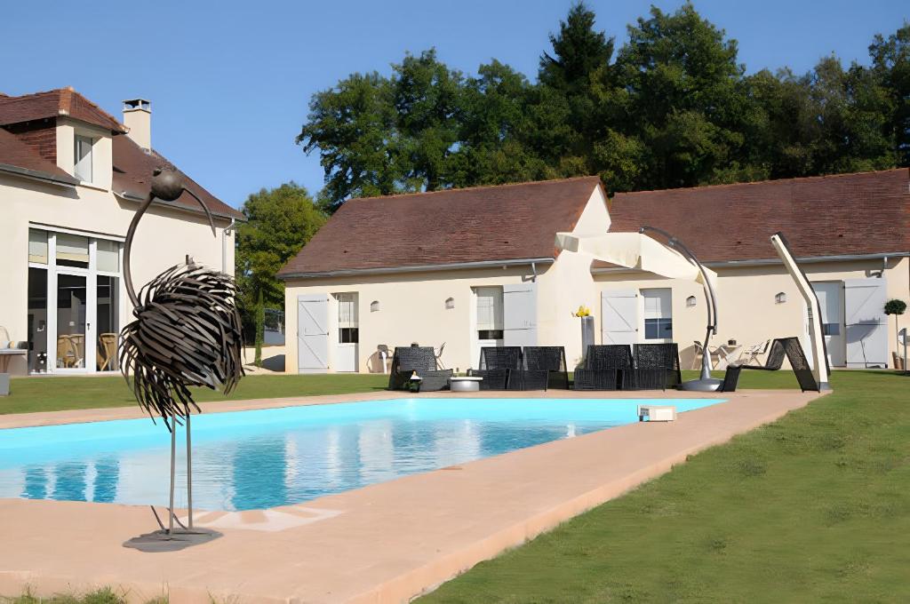 une maison avec une piscine devant dans l'établissement Domaine La Truffière des Mérigots, à Gabillou