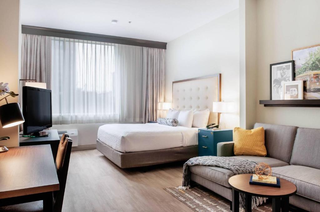 a hotel room with a bed and a couch at St Charles Coach House, an Ascend Collection Hotel in New Orleans