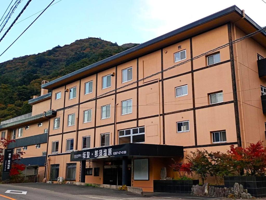 een groot bruin gebouw met een bord erop bij 坂聖 那須塩原 in Nasushiobara