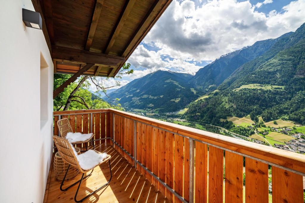 a balcony with chairs and a view of mountains at Bergchalet Prantach W95 in San Martino