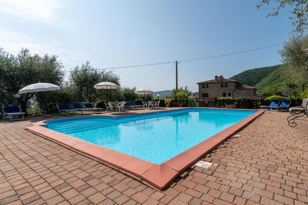 a large swimming pool on a brick patio at Appartamento La Stella in Corgna