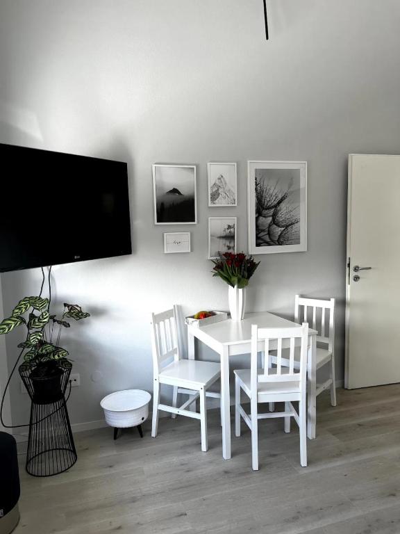 ein weißes Esszimmer mit einem weißen Tisch und Stühlen in der Unterkunft Ferienwohnung Lorenz in Olching
