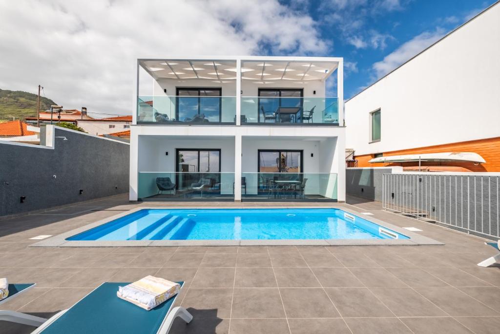 a villa with a swimming pool and a house at Golden Home V in Caniçal