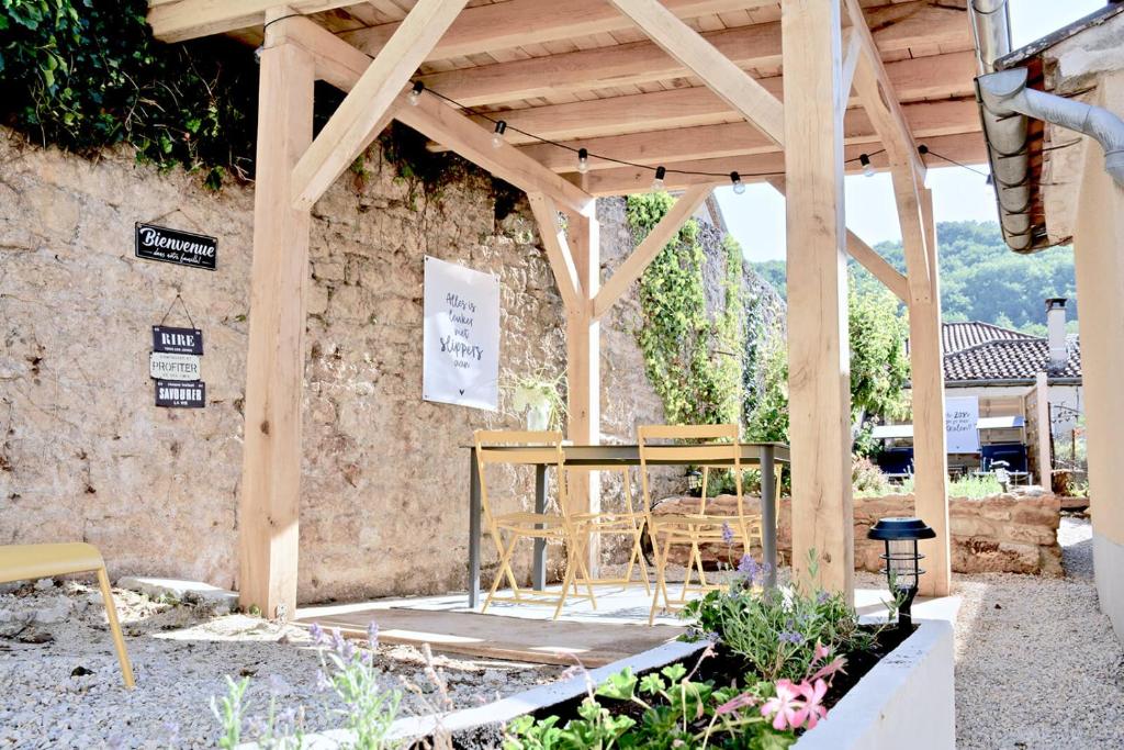 a table and chairs under a wooden pergola at Vakantiehuis Lott Duravel in Duravel