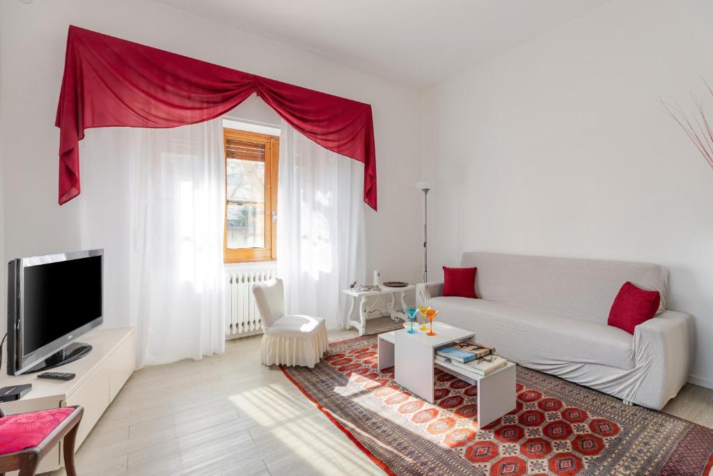 a white living room with a couch and a tv at Cappuccini apartment lower in Oristano