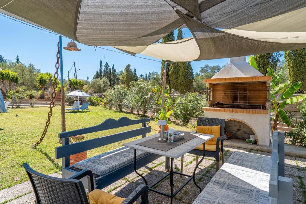 Un patio con mesa y sillas y una chimenea. en Starry Sky Luxury Apartment 6, en Áno Lefkímmi