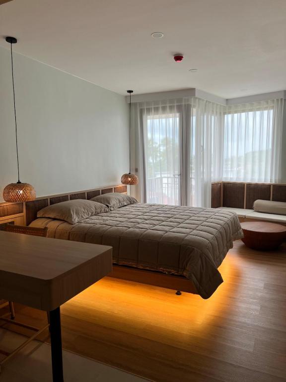 a bedroom with a large bed and a large window at Studio in a modern complex Wing Samui Condo in Amphoe Koh Samui