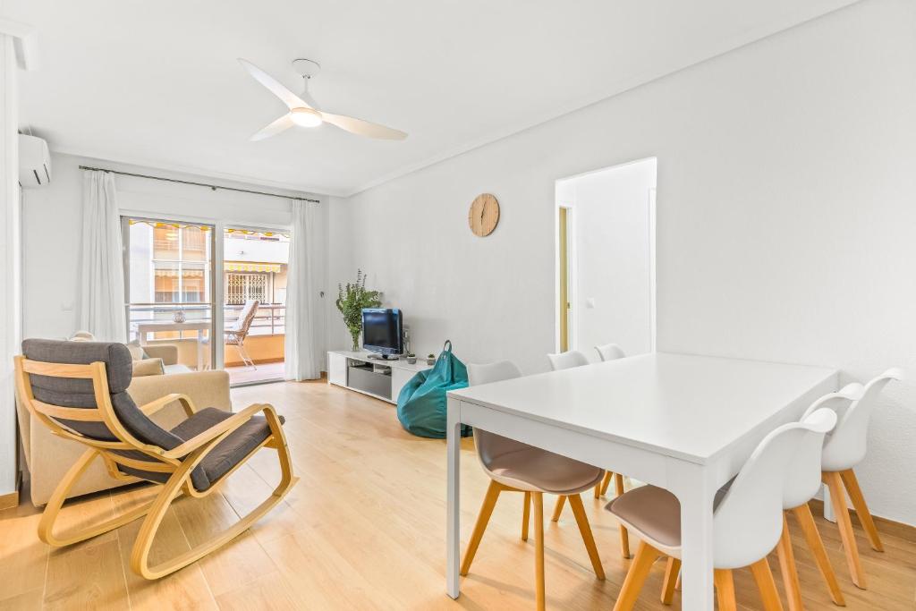 a white dining room with a white table and chairs at Moriones Playa in Torrevieja