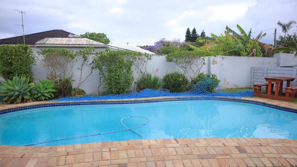 a swimming pool in a yard with a fence at Comfy stay in East London