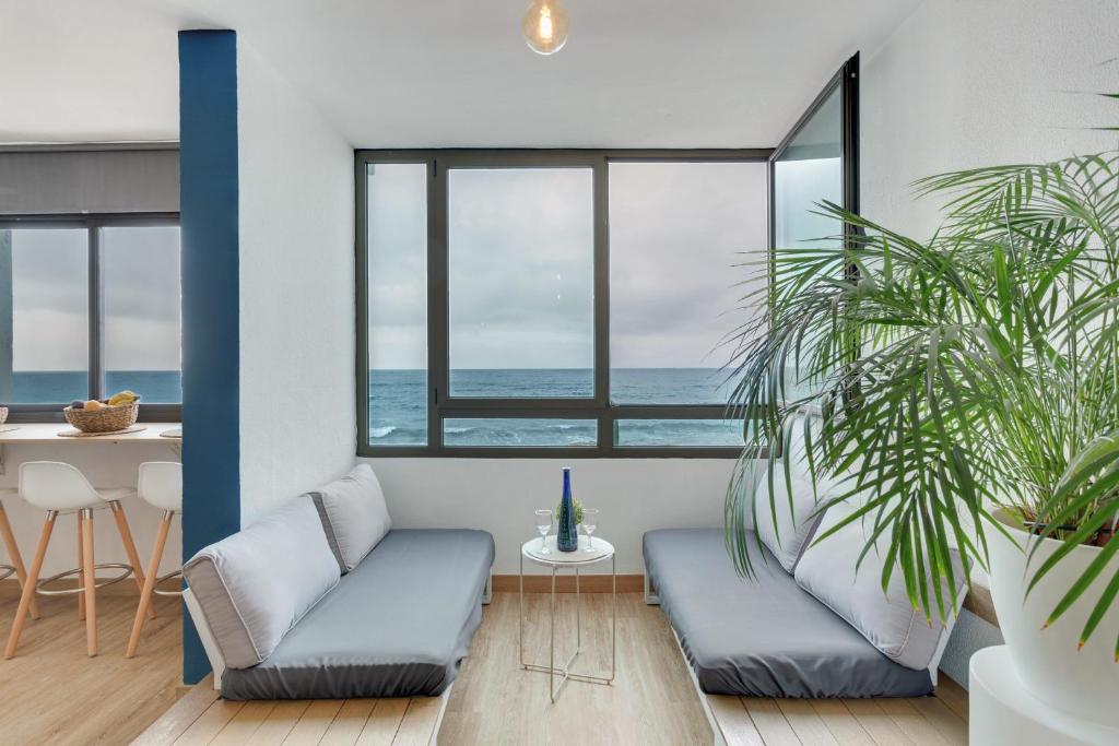 Una sala de estar con dos sofás azules y una mesa. en Casa Adrimar, en San Felipe