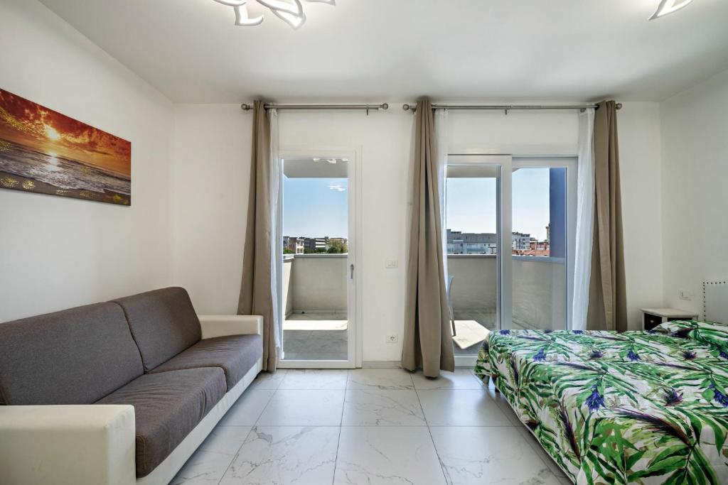 a living room with a couch and a bed at Planet Suite 504 in Bibione
