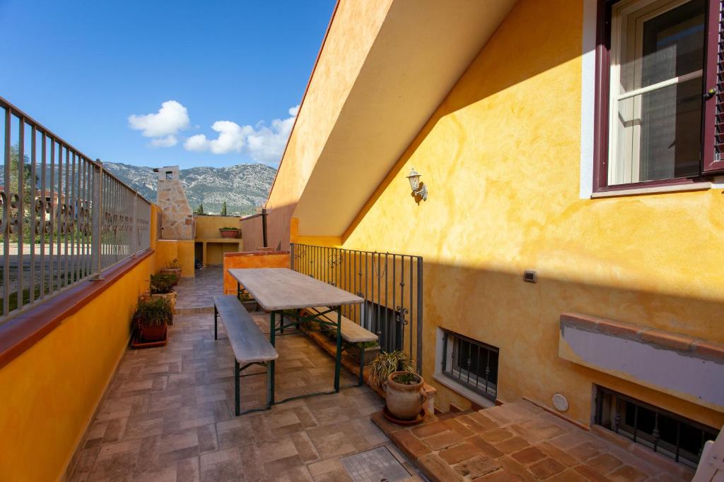 a balcony with a table and chairs on a building at Appartamento Mariposa in Orosei