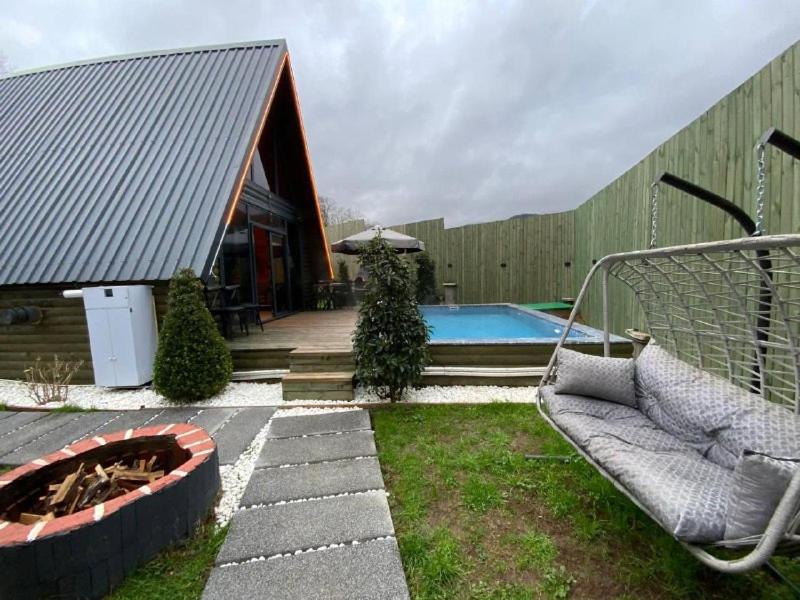 Un patio trasero con piscina, sofá y fogata. en Moon Bungalov, en Sapanca