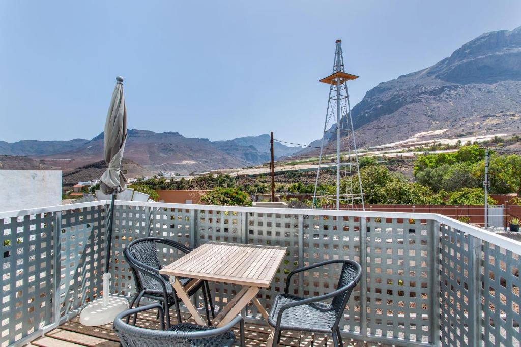 a table and chairs on a balcony with a windmill at El Blanquizal A in La Aldea de San Nicolas