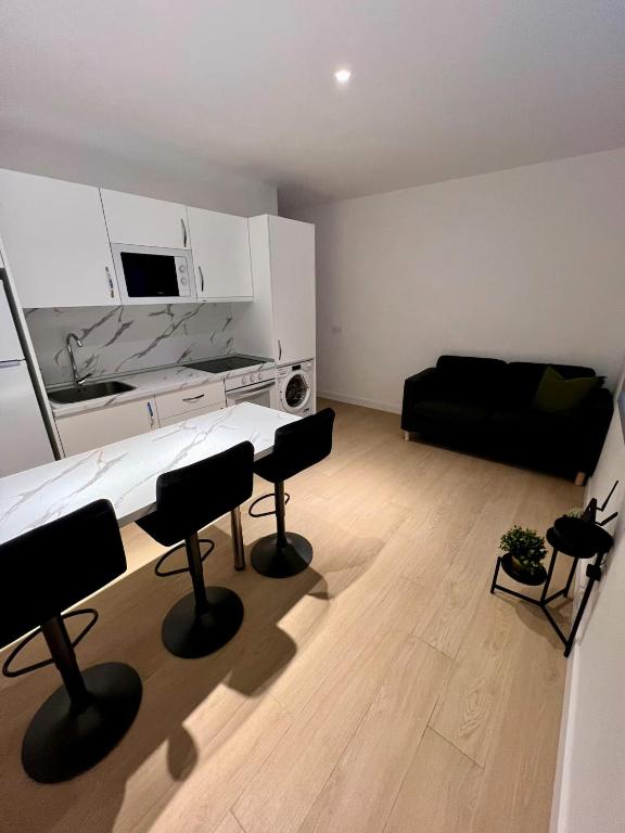 ein Wohnzimmer mit einer Couch und einem Tisch und Stühlen in der Unterkunft Encantador Apartamento Familiar in La Cuesta