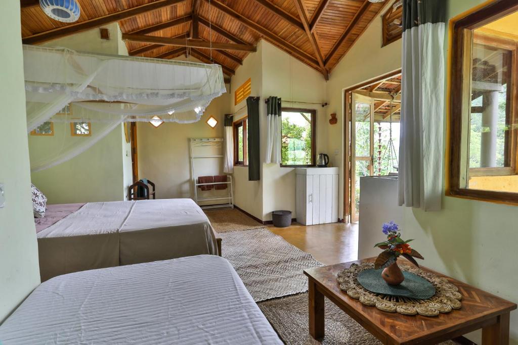 un salon avec deux lits et une table dans l'établissement Natural Mystic Sanctuary, à Deniyaya