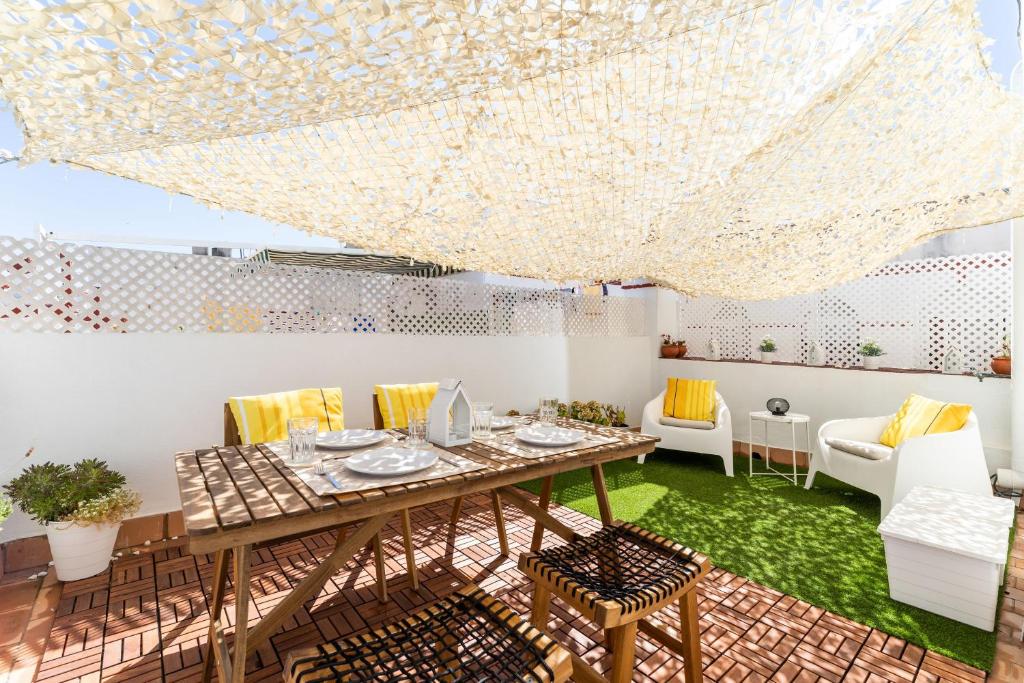 Una sala de estar con una mesa y sillas de madera. en La Torre de Menacho, en Cádiz