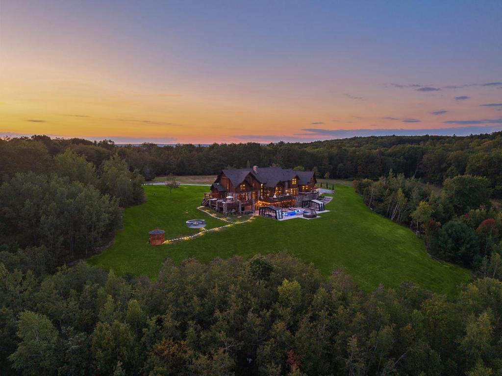 an aerial view of a large house on a green field at Pinnacle Pointe by Relaxtay 600 Acre Private Luxury Estate with Spa, Pool, Theater and Lake in High View