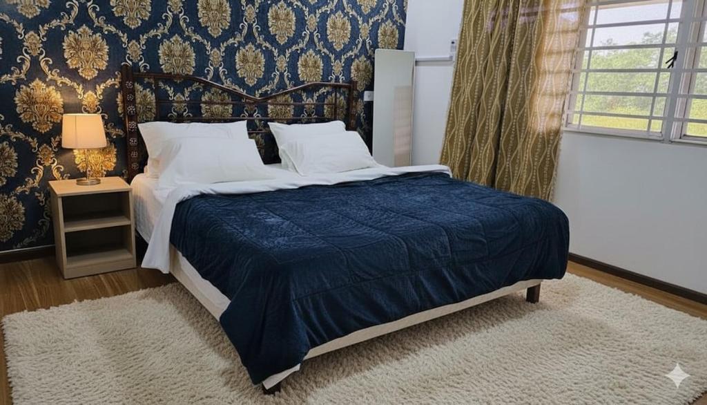 une chambre avec un lit avec une couette bleue dans l'établissement Feel Borneo Cozy Homestay in Penampang, à Penampang