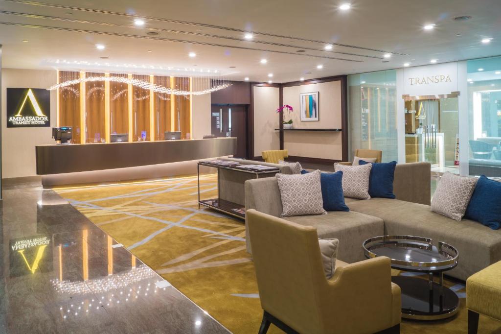 Ambassador Transit Hotel - Terminal 2 في سنغافورة: لوبي فيه كنب وكراسي في محل