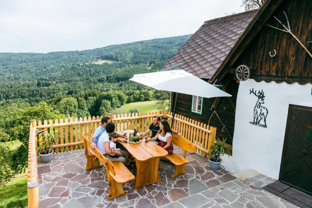 un grupo de personas sentadas en una mesa en un patio en Connyhaus St Oswald ob Eibiswald, en Sankt Oswald ob Eibiswald