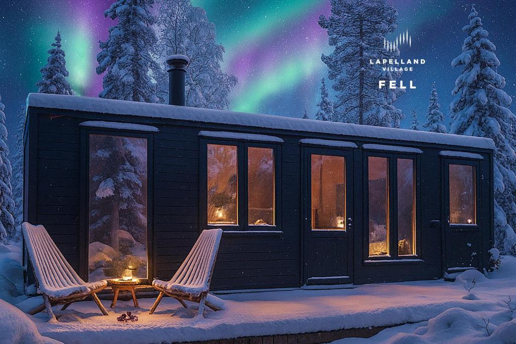 Una cabaña en la nieve con dos sillas y la aurora boreal. en Lapland Landscape XL Cabin with Nature View, Sauna, Fireplace & Kitchen, Sodankylä, Luosto, Fell Village, en Luosto
