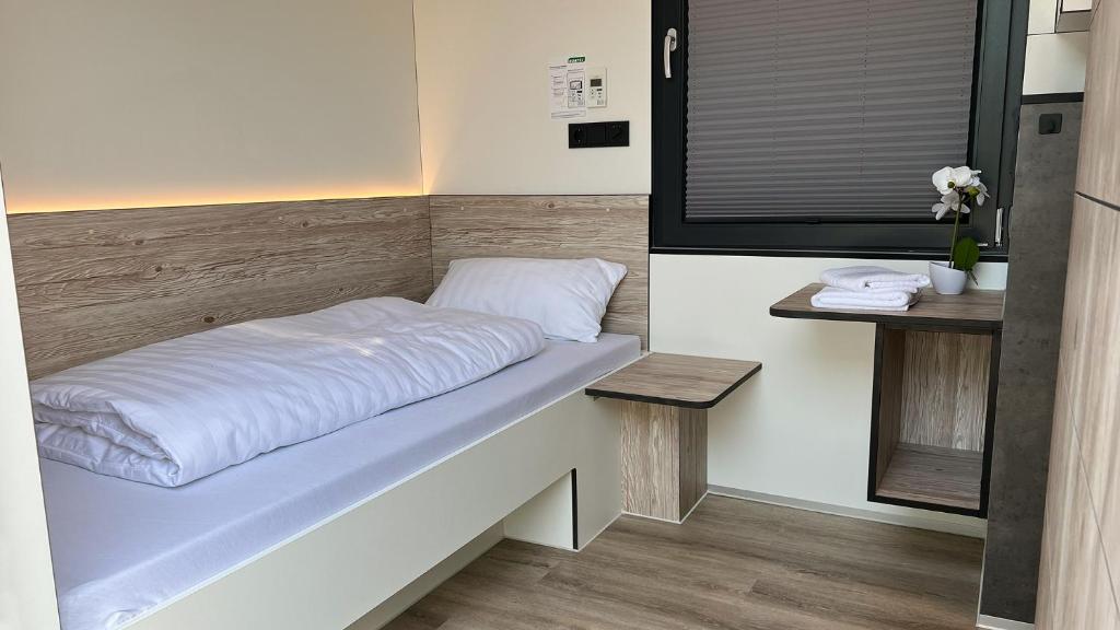 a bedroom with a bed with white sheets on it at Roatel Schipkau (A13) my-roatel-com in Schipkau