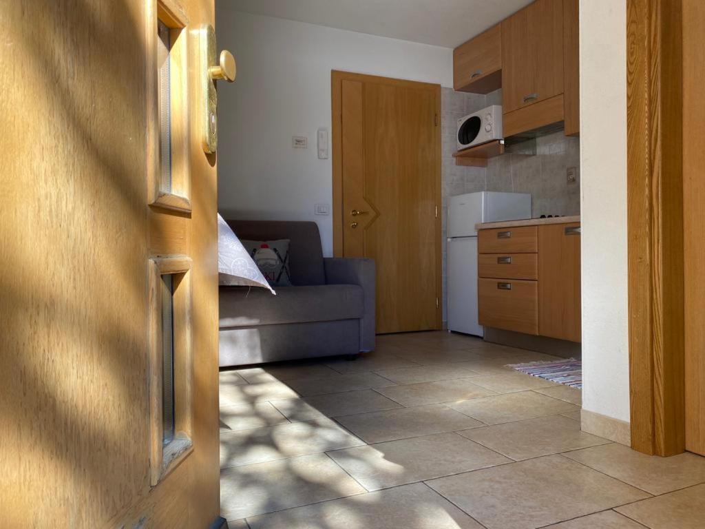 een woonkamer met een bank en een keuken bij Appartamento Piz Orsera in Livigno