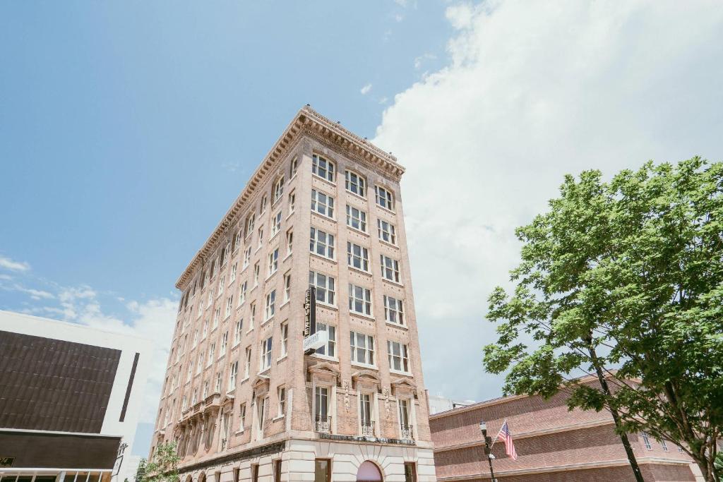 a tall brick building on a city street at The Esquire Hotel Downtown Gastonia, an Ascend Collection Hotel in Gastonia