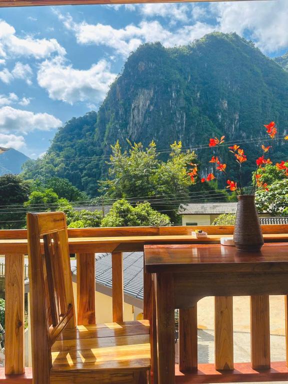 une table et un vase sur un balcon avec une montagne dans l'établissement Nong Khiaw IVY Mountain View, à Nongkhiaw