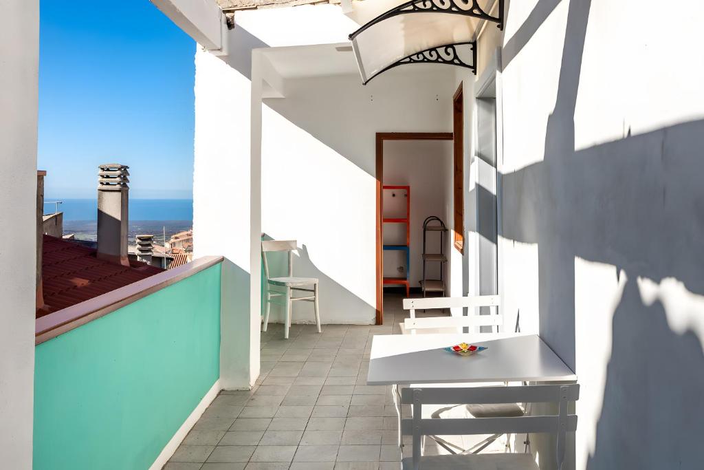 クーリエリにあるDomo Mea - La Tua Casa In Sardegnaの建物の上にテーブルと椅子が置かれたバルコニー