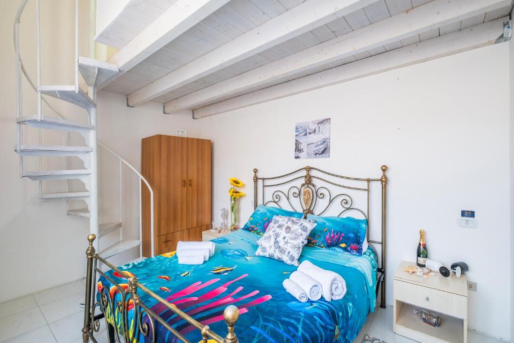 a bedroom with a blue bed and a staircase at Villetta Rhapsody by the Sea in Porto Cesareo