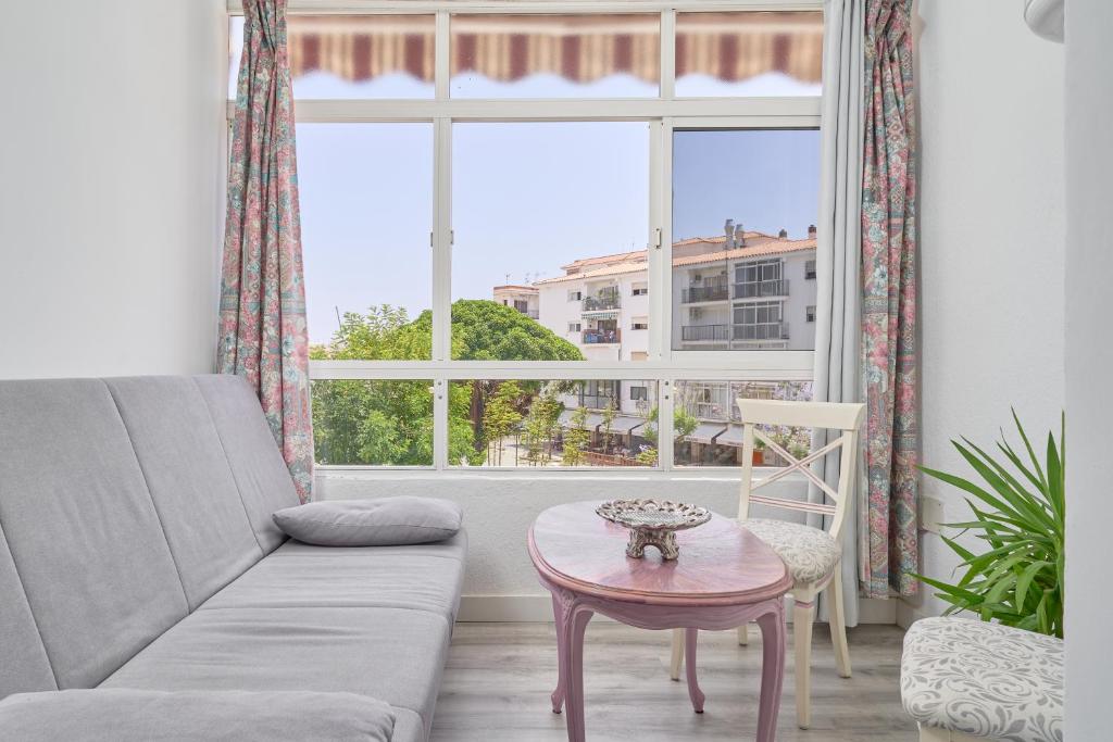 un salon avec un canapé, une table et une fenêtre dans l'établissement Loft La Marina in Nerja, à Nerja