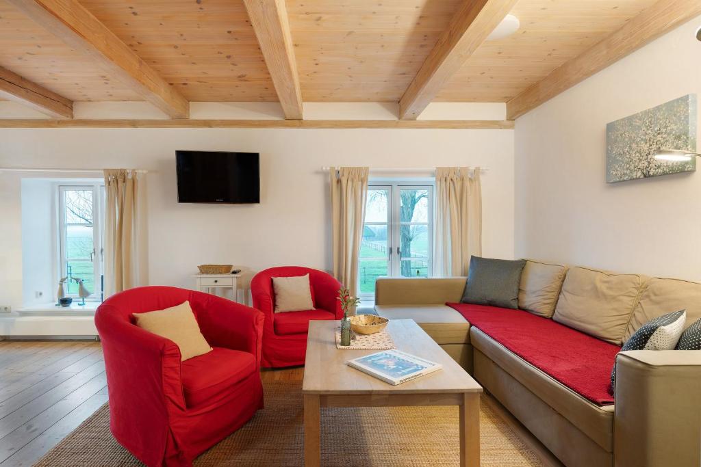 - un salon avec un canapé et deux fauteuils rouges dans l'établissement Haus Mühlenhof 3, à Hillgroven