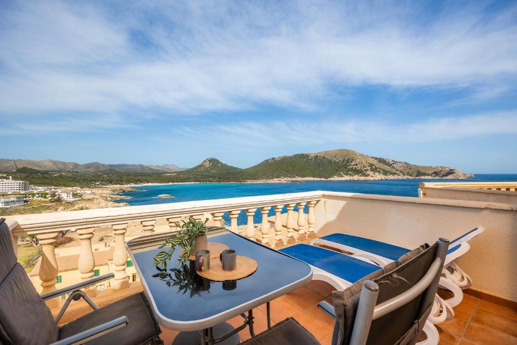 een balkon met een tafel en stoelen en de oceaan bij Perleta in Cala Ratjada