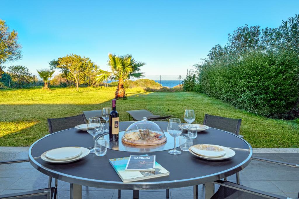 a table with a bottle of wine and glasses at Villa Marconi Apartment 6 in Golfo Aranci