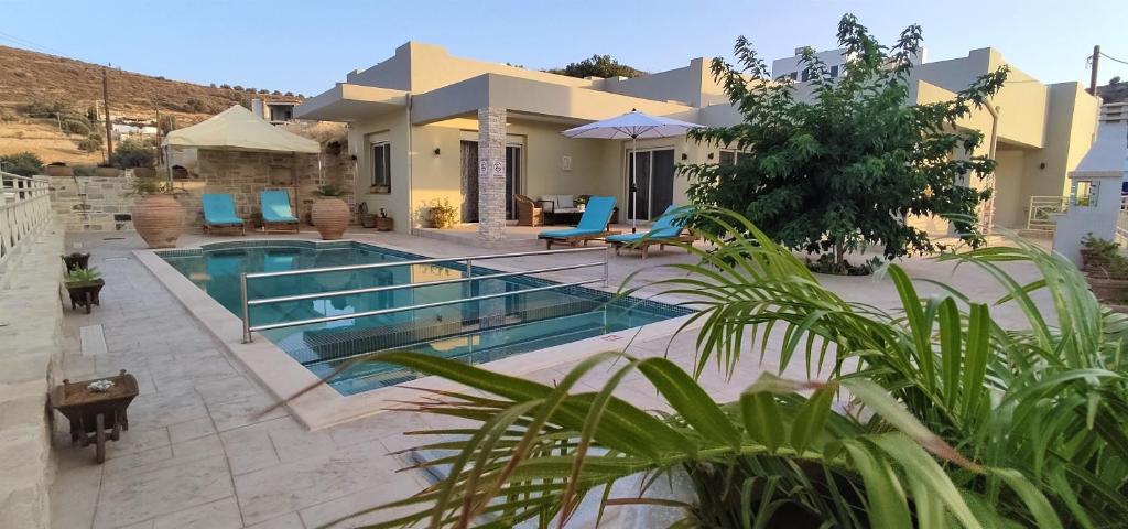 a villa with a swimming pool in front of a house at Villa Urania Kamilari in Kamilari