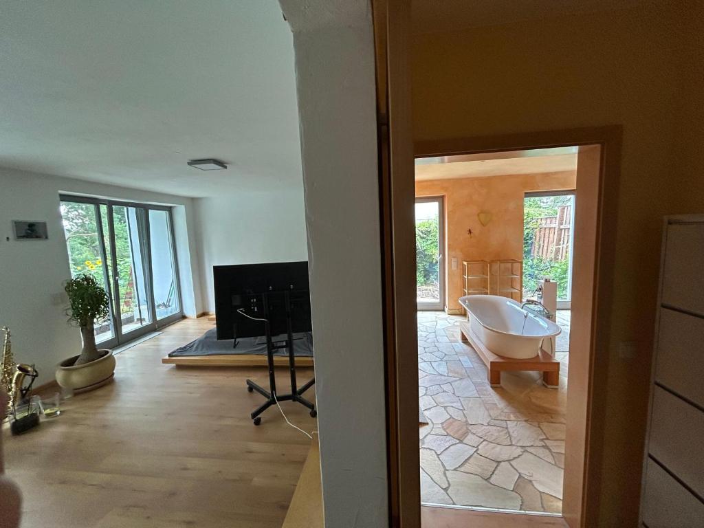 a living room with a tub in the middle of a room at Separate Area mit Schlafzimmer und Badezimmer in Heroldsberg