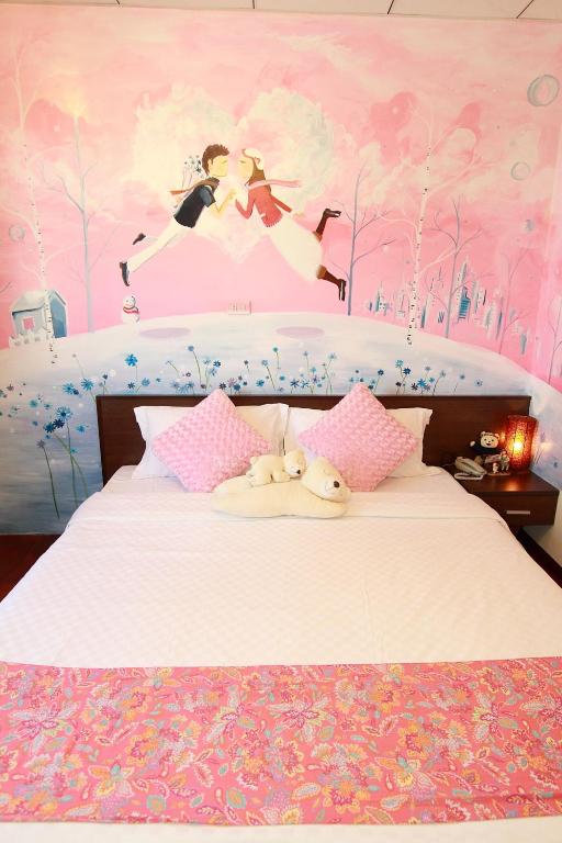 a bedroom with a large bed with a pink wall at Love in Hualien B&amp;B in Hualien City