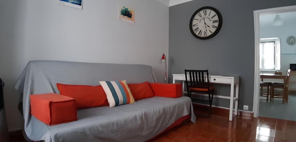 a living room with a couch and a clock on the wall at Casa do Mestre By Gt House in Évora