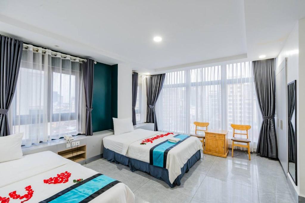 Una habitación de hotel con dos camas y una mesa y sillas. en Jason Residencia One Hotel, en Phnom Penh