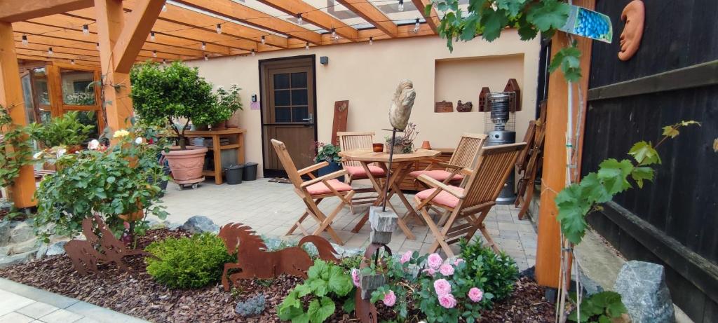 un patio con pérgola de madera, mesa y sillas en Ferienwohnung Am Dächsberg, en Plauen