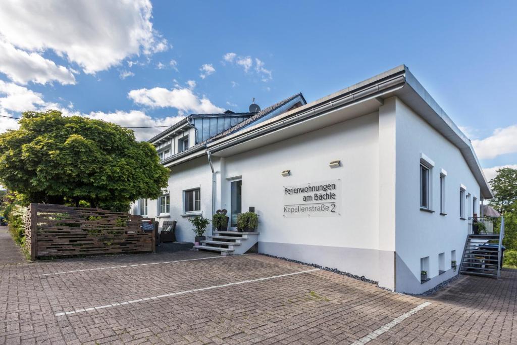 un edificio bianco con un cartello sul lato di Ferienwohnung Am Bächle a Weilheim